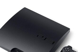 PlayStation 3 console beside a PC displaying the RPCS3 emulator interface.